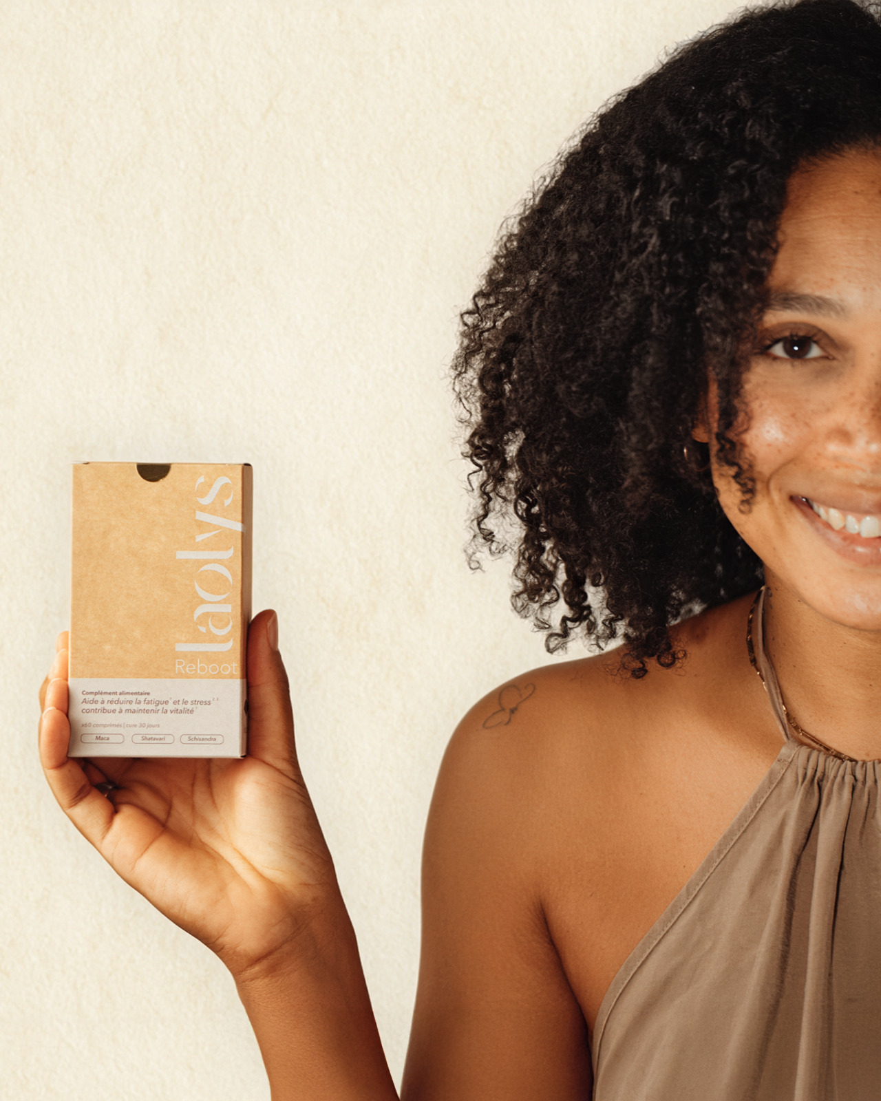 Femme tenant une boîte du complément alimentaire Laolys Reboot